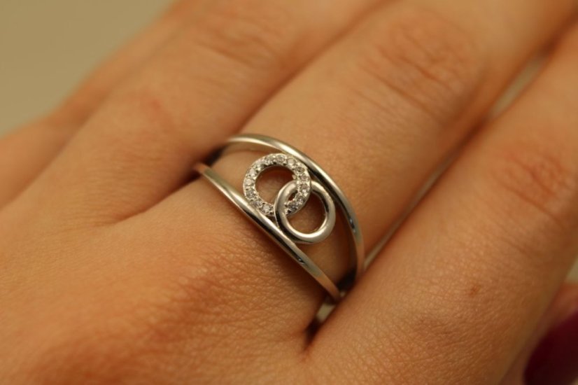 Prsteň- dva kruhy medzi obručou-číre zirkóny-rhodium-striebro